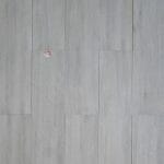 Montana Ash is a rectified porcelain tile from Spain with Wood Look on a grey background