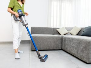 How to Clean Porcelain Tile Floors 1 Woman vacuuming living room floor tiles