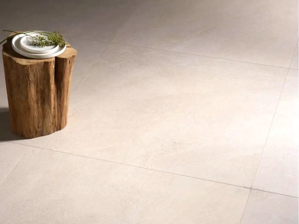 close up picture of a floor with 48x48 tile that looks like limestone in very light beige color and minimal design