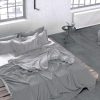 a modern bedroom with grey concrete look tile flooring