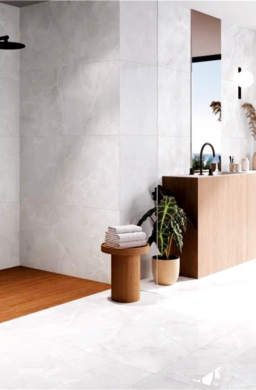 a bathroom floors and shower walls with a polished porcelain tile that looks like Onyx in very light colors