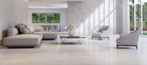 a modern interior with big windows that connects with the front yard with furniture and the floor in light earth tones