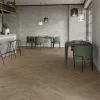 A modern kitchen with a white island and walnut color wood looking porcelain floor