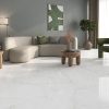 a living room with huge tile that that loos like a white marble with beige veining