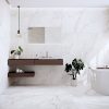 a bathroom scene with 63x63 tile white marble floor and wall in warm tones