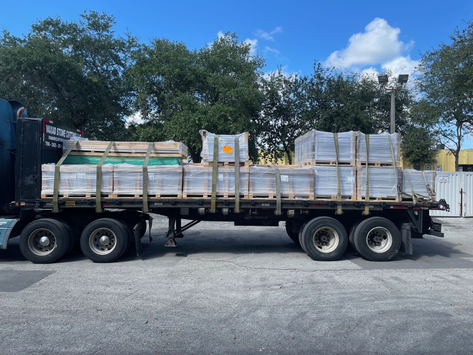 What is Wholesale Tile and How Are Tiles Priced? 2 Palletized tile shipment on a flatbed truck showing the weight and volume of freight shipping