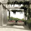 an elegant patio with 48x48 limestone beige in & out tile
